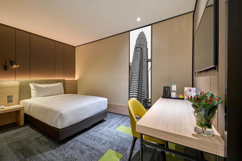 A compact airport sleeping cabin with a bed, a desk and a curtained window.