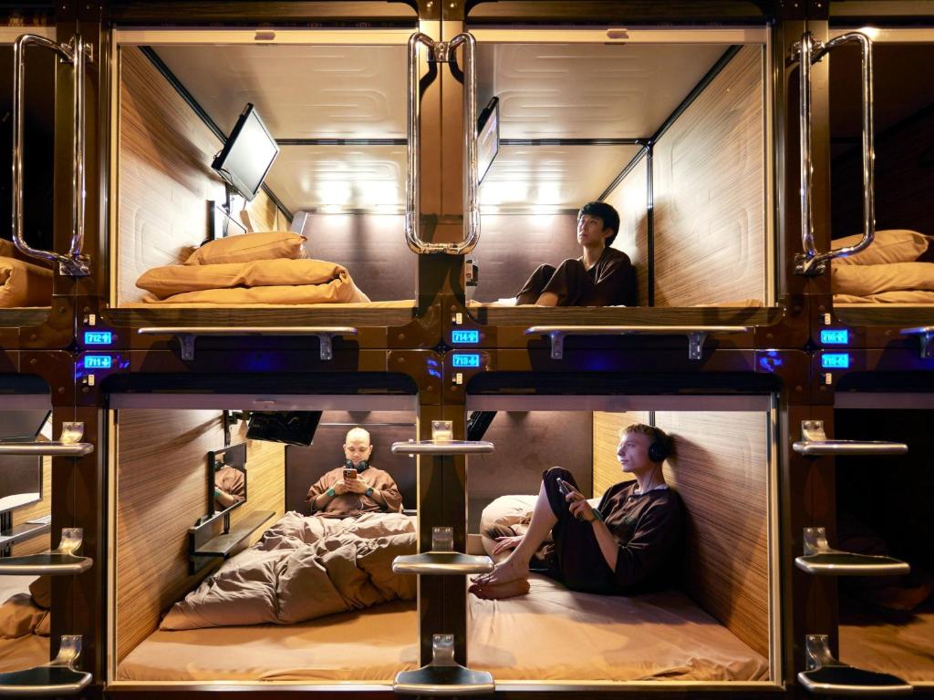 A quiet floor of stacked sleeping units behind curtains in a city building.