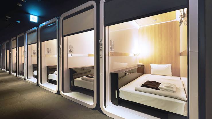 A quiet corridor lined with identical fitted sleeping units in flat light.